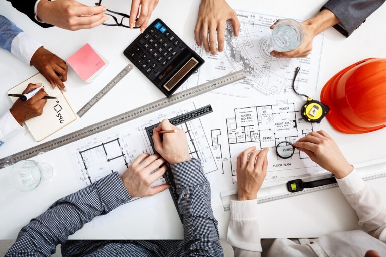 Picture of businessmen's hands on white table with documents and drafts
